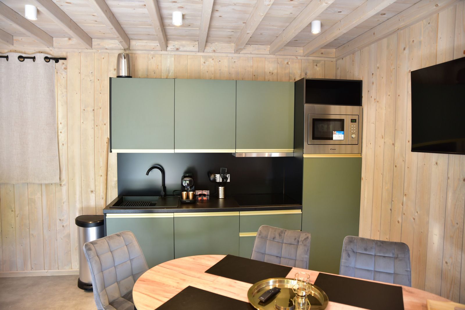 Modern kitchen in Ecolodge vacation home in Houffalize, Ardennes, Belgium, with stylish decor and comfortable dining area.