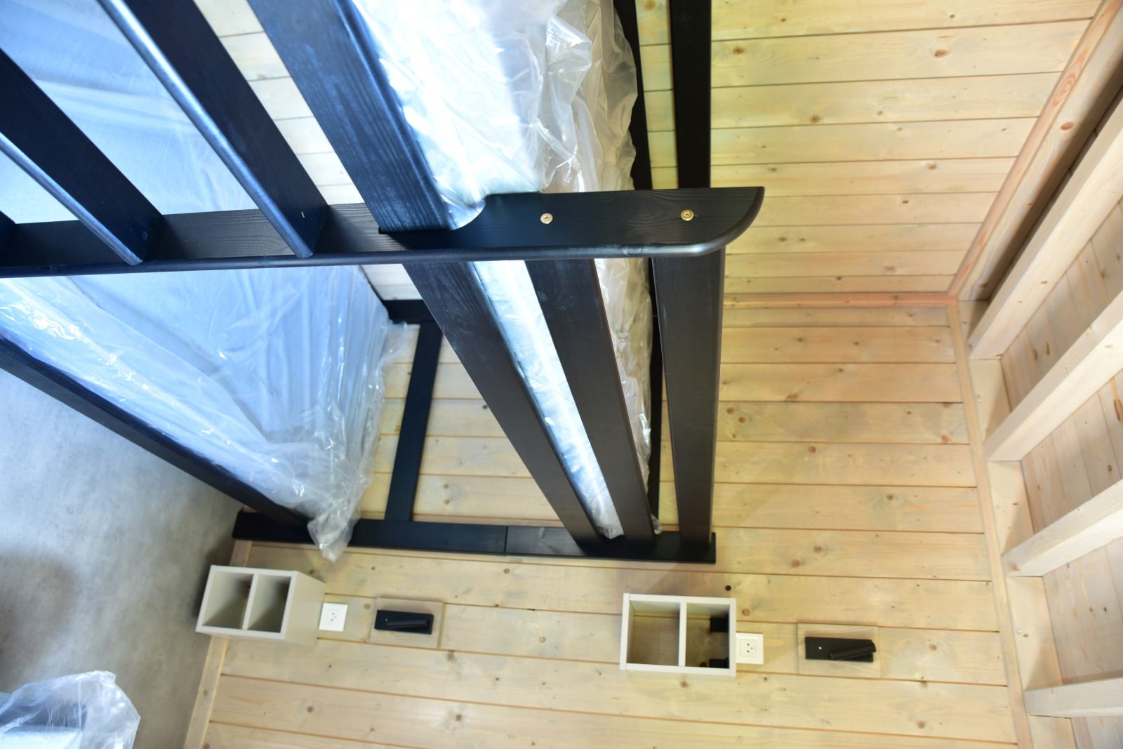 Cozy bedroom in Ecolodge, a vacation home in Houffalize, Ardennes, with wooden interior and comfortable beds.