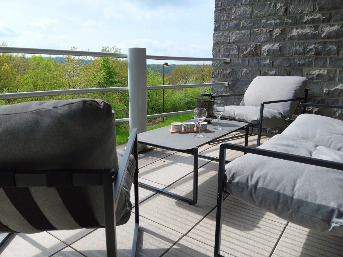 Gezellige woonkamer in vakantiehuis Castelgolf, Barvaux, Ardennen, met grote ramen en moderne inrichting voor een ontspannen verblijf.