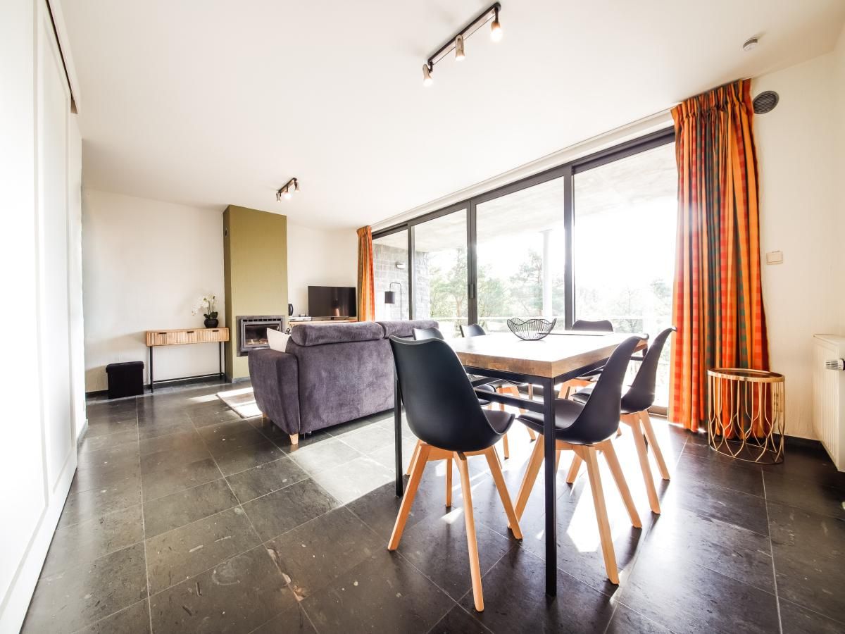 Gezellige woonkamer in vakantiehuis Castelgolf, Barvaux, Ardennen met moderne open haard en stijlvolle inrichting.
