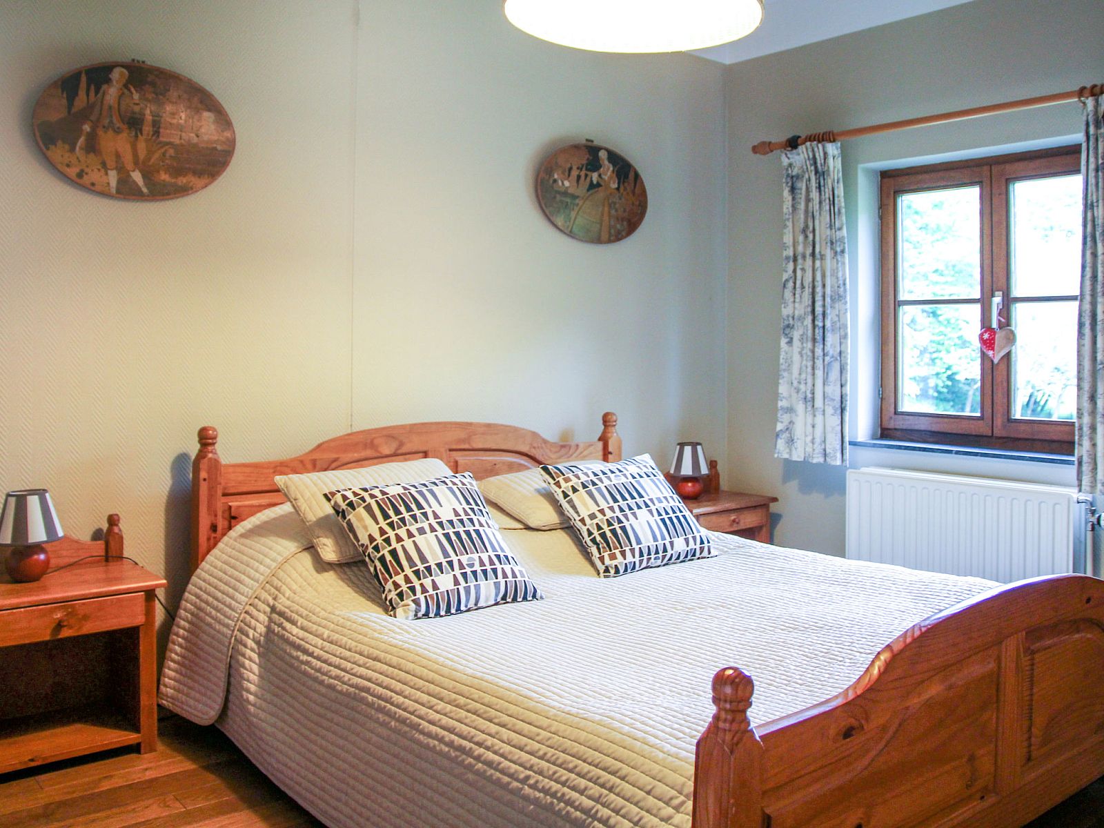 Sfeervolle slaapkamer in Vakantiehuis La Rochette, gelegen in Marche-en-Famenne, Ardennen, Belgie, met rustieke houten meubels.