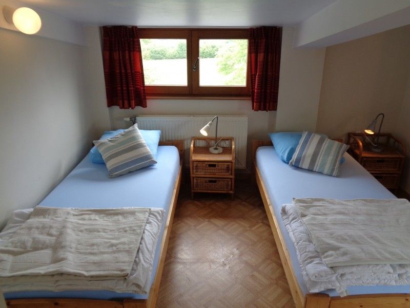 Comfortabele slaapkamer in La Terra vakantiehuis Durbuy, met houten bedden.