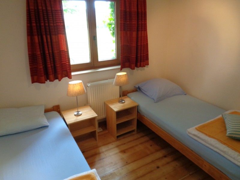 Slaapkamer met twee bedden in La Terra vakantiehuis Durbuy, gezellig en licht.