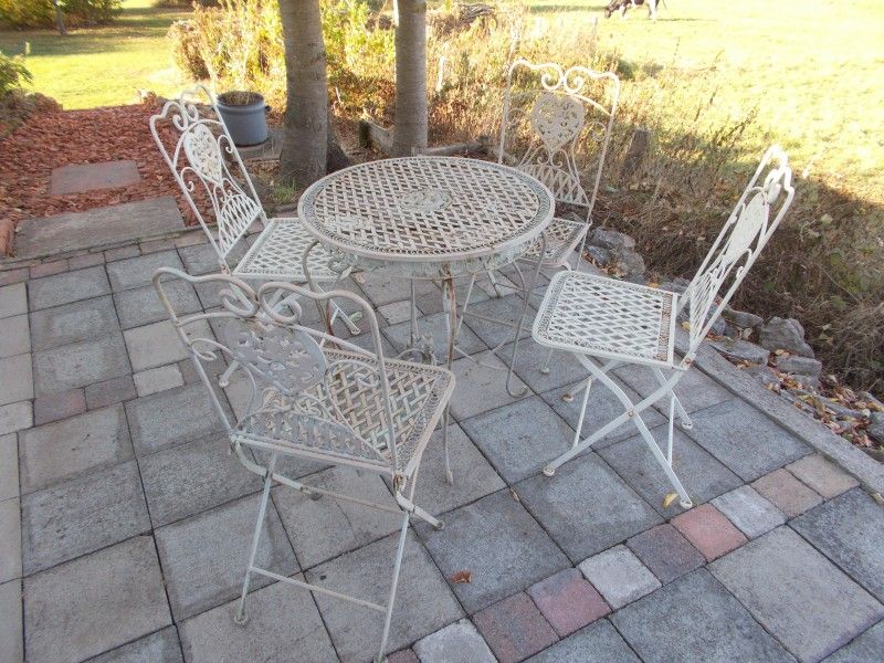 Terras met smeedijzeren meubels bij La Terra vakantiehuis, Durbuy, voor buitenmaaltijden.
