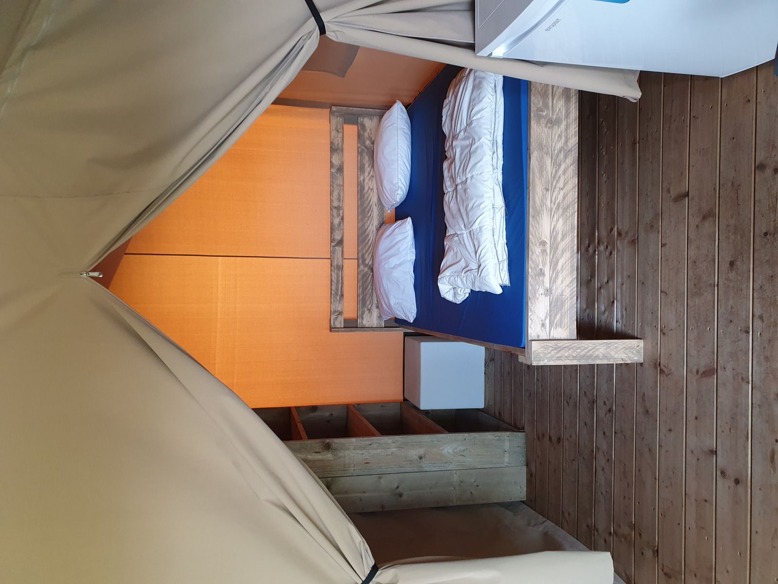 Gezellige slaapkamer in Safaritent, een glamping lodge in La Roche-en-Ardenne, Ardennen, Belgie met houten interieur en comfortabele bedden.