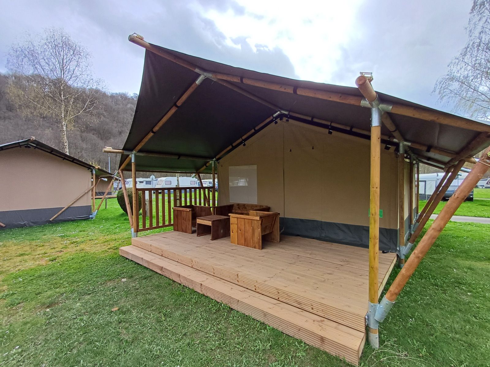 Veranda van Safaritent in La Roche-en-Ardenne, Ardennen, Belgie, biedt een rustieke glamping ervaring te midden van groene natuur.