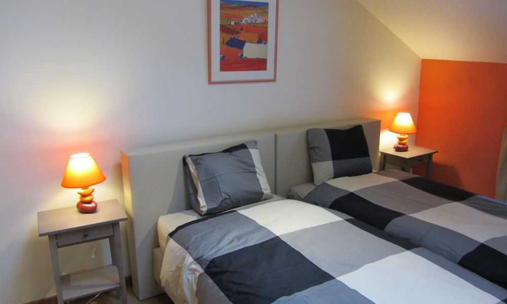 Gezellige slaapkamer met kleurrijk beddengoed in Belle Campagne, vakantiehuis in Erezee, Ardennen, Belgie.