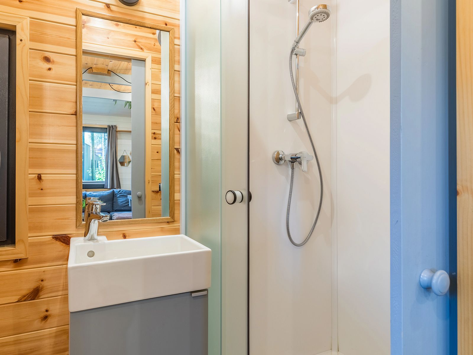 Moderne badkamer in 2-persoons tiny house 2BY in Poix-Saint-Hubert, Ardennen, Belgie, met houten afwerking en comfortabele douche.