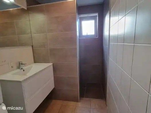 Moderne badkamer in Seaside Village, huisje 77, vakantiehuis in Vosseslag, De Haan aan de Belgische kust met stijlvolle tegelafwerking.