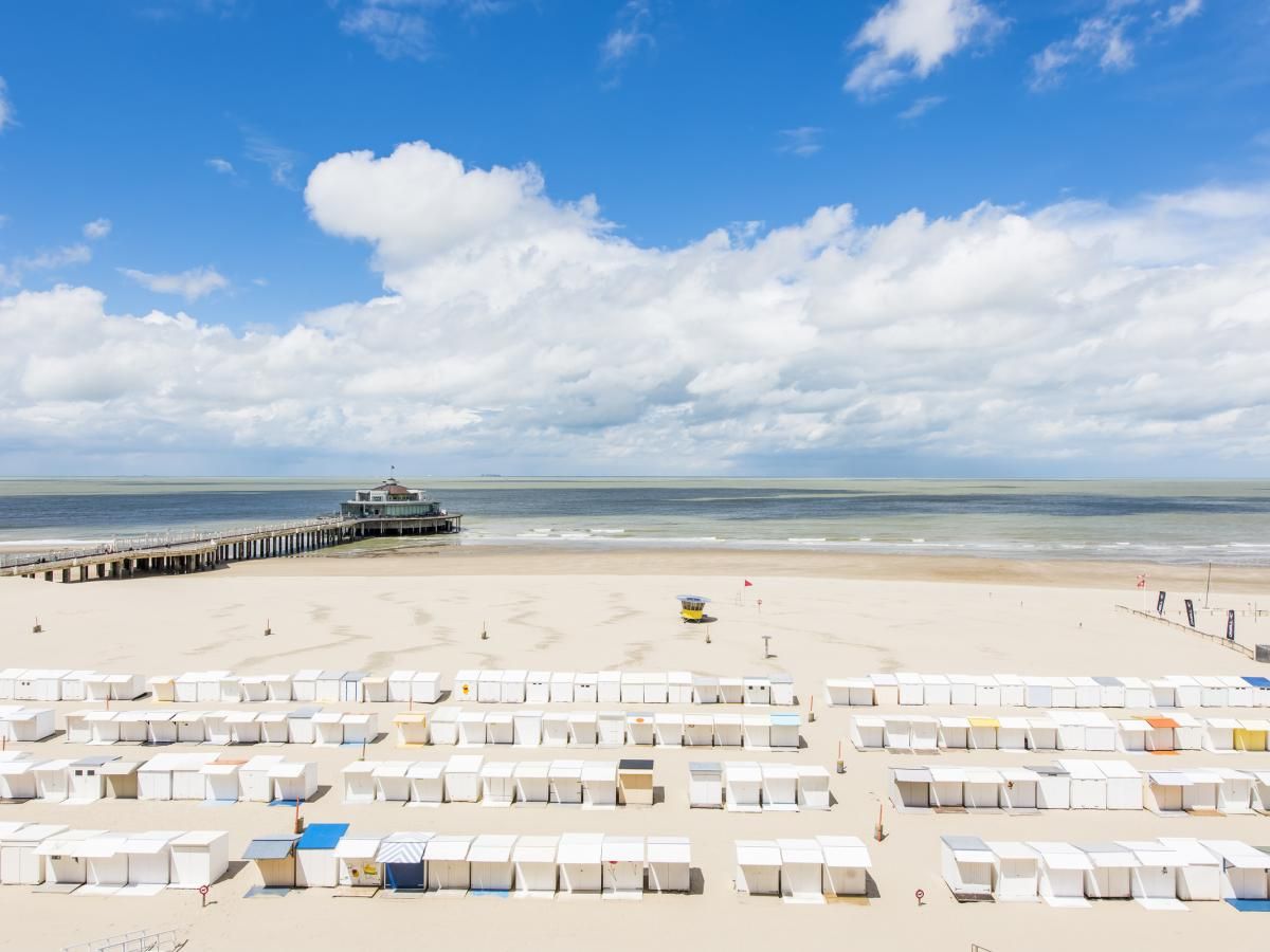 Uitzicht op het strand bij vakantiehuis Ter Duinen - 0601 in Blankenberge, Belgische kust, met zee en pier op de achtergrond.