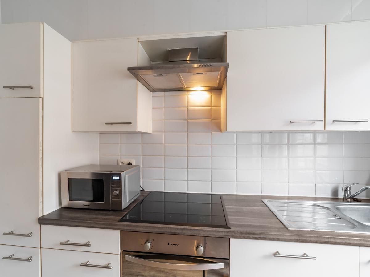 Moderne keuken van vakantiehuis Ijzerstraat - 52 in Blankenberge, Belgische kust, met inductiekookplaat en magnetron.