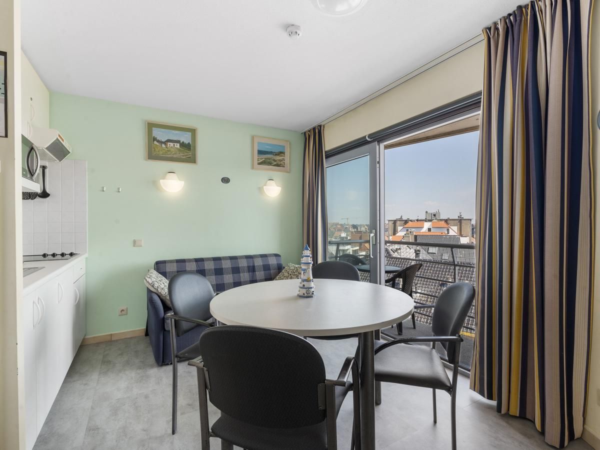 Gezellige woonkamer van Ocean Suites - 714 in Blankenberge, Belgische kust, met uitzicht op de stad vanaf het balkon.