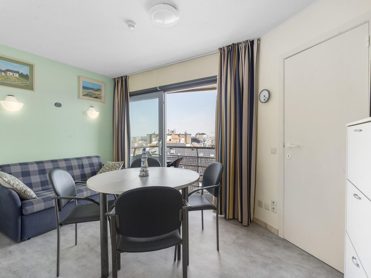 Gezellige woonkamer van Ocean Suites - 714 in Blankenberge, Belgische kust, met uitzicht op de stad vanaf het balkon.