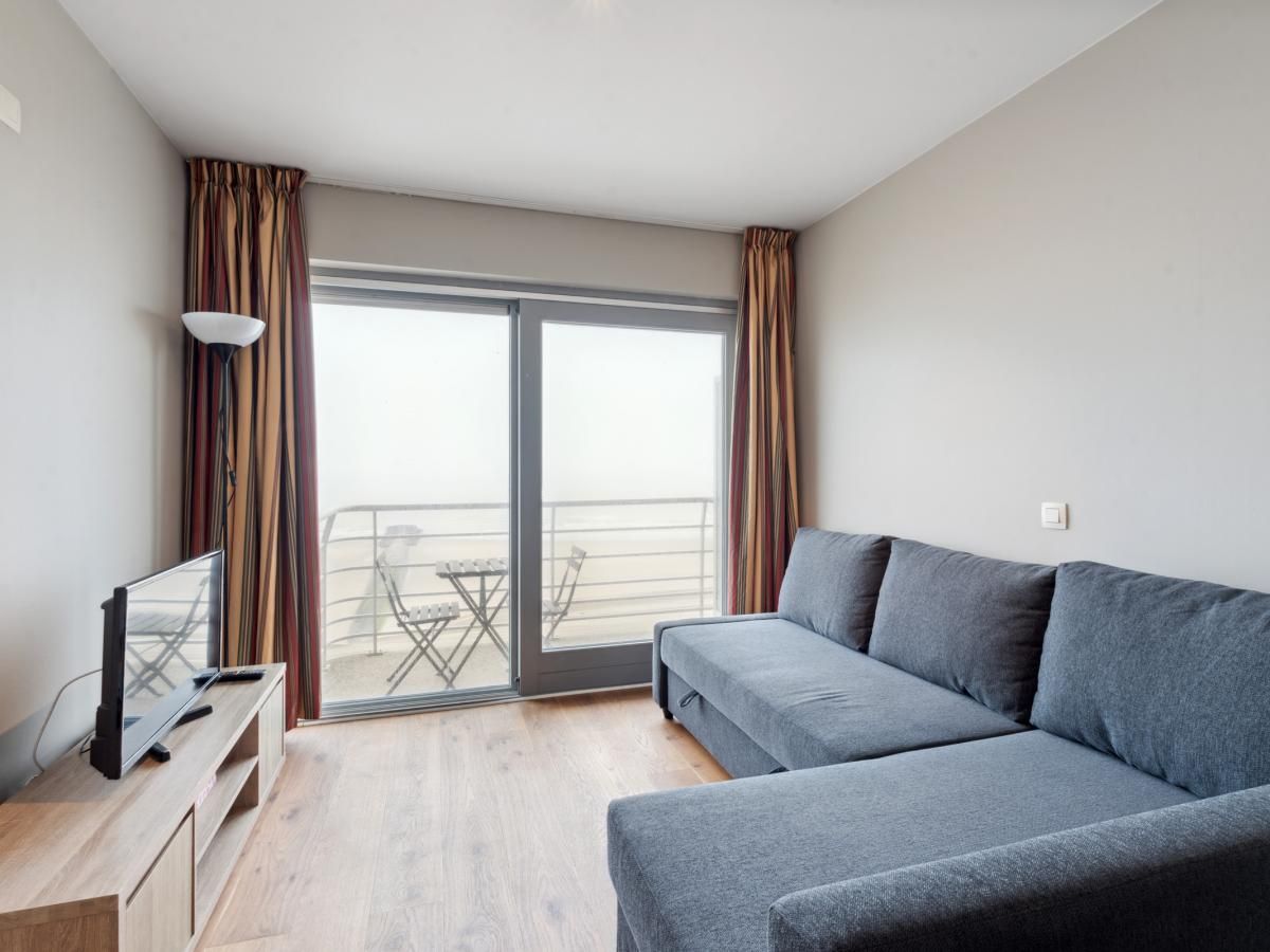Gezellig woonkamerinterieur van Ocean Suites - 1004, vakantiehuis aan de Belgische kust in Blankenberge, met uitzicht op het terras.