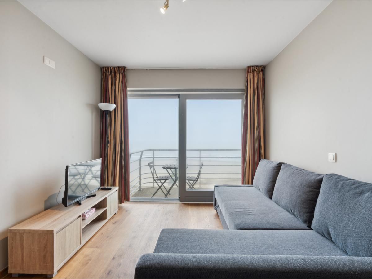 Gezellige woonkamer van Ocean Suites - 1004 in Blankenberge, Belgische kust, met uitzicht op zee vanaf het balkon van dit vakantieappartement.