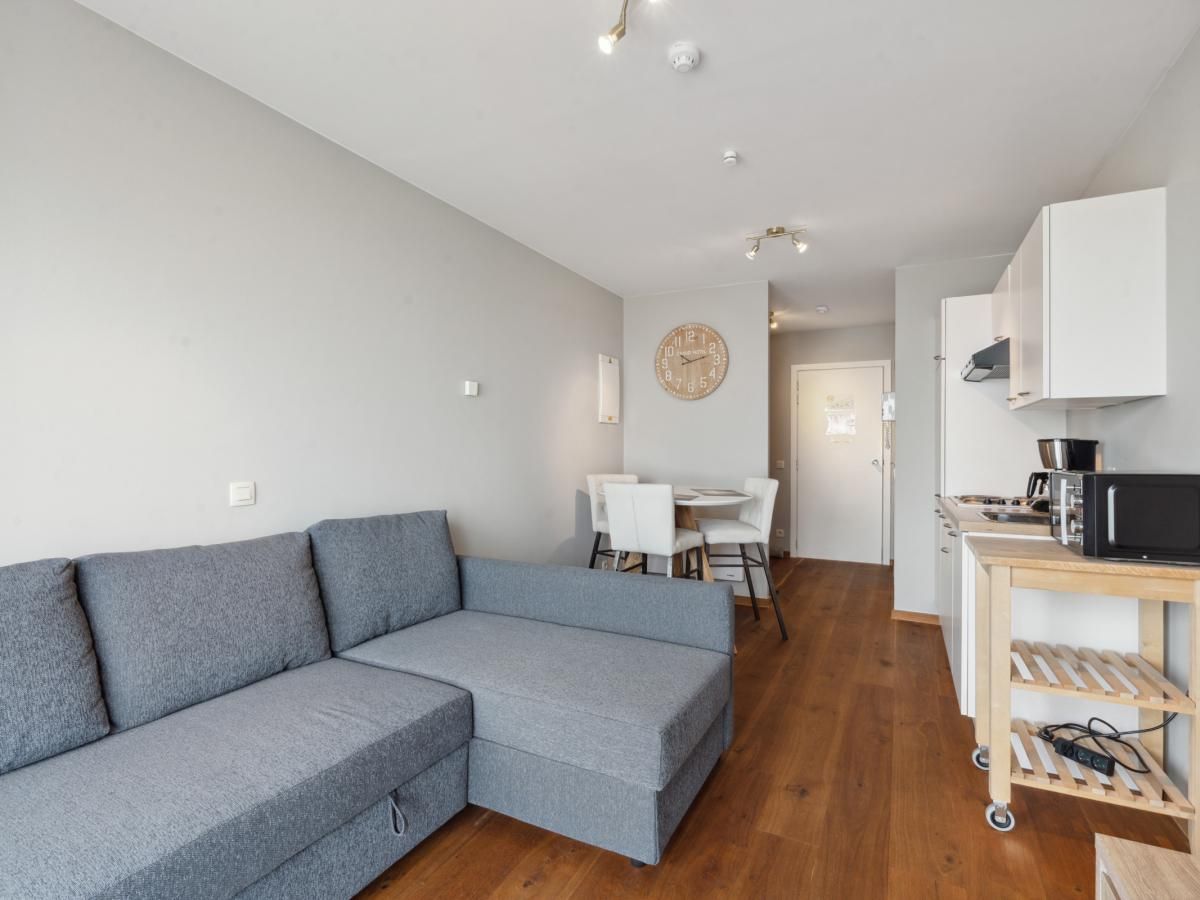 Moderne woonkamer in Ocean Suites - 1004, vakantiehuis in Blankenberge aan de Belgische kust, met comfortabele zithoek en eetruimte.