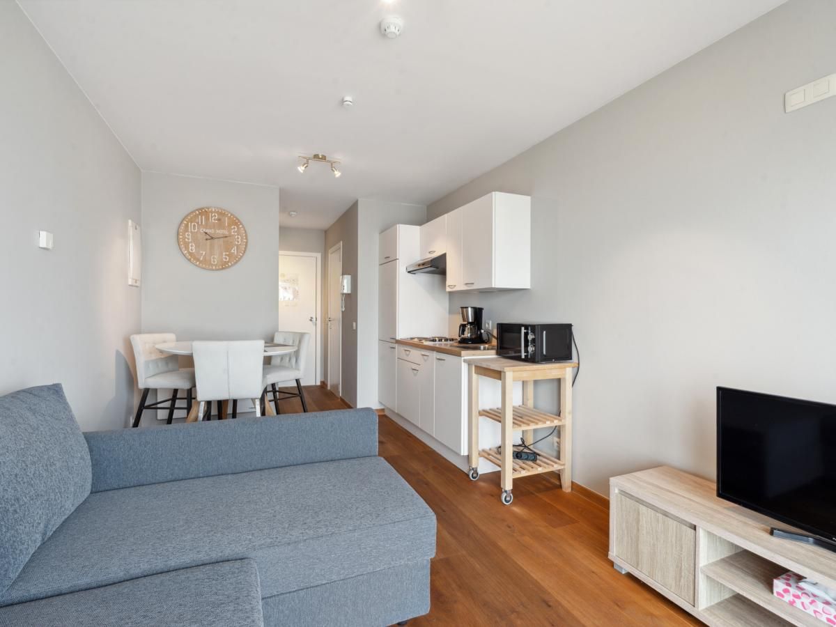 Gezellige woonkamer en keuken in Ocean Suites - 1004, vakantieappartement aan de Belgische kust in Blankenberge.