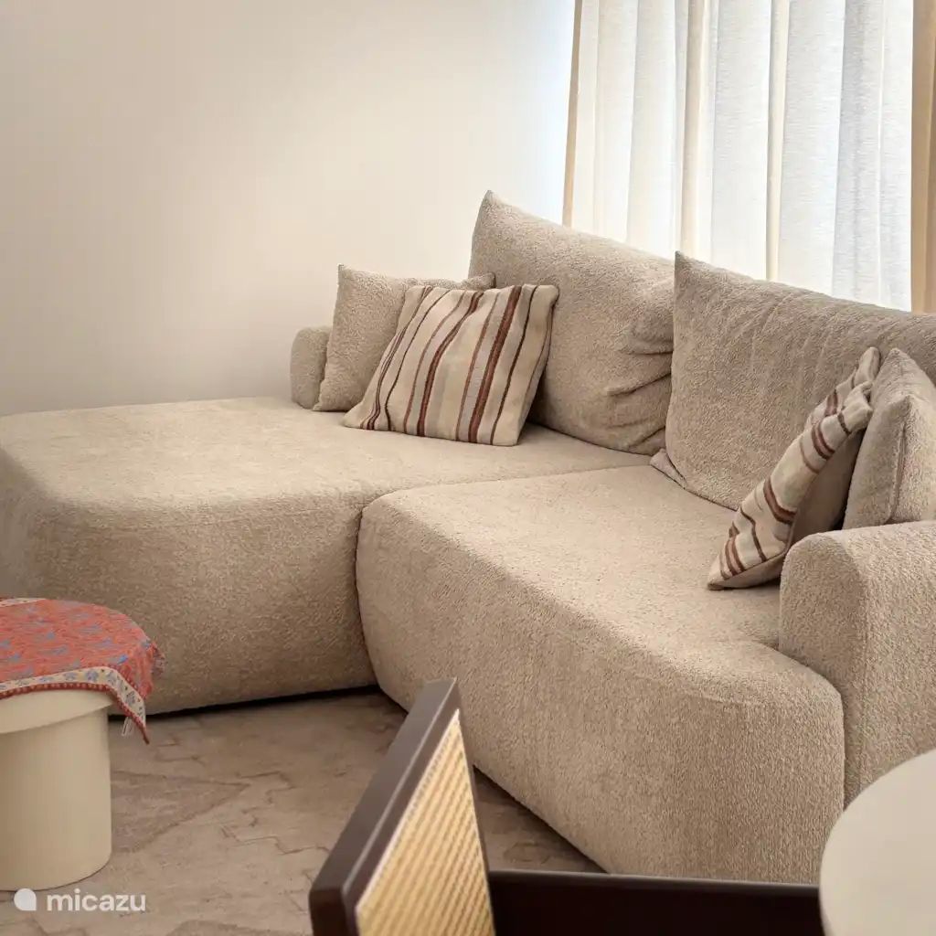 Cozy living room in the Let's Go Koksijde apartment on the Belgian coast, featuring a comfortable sofa and stylish decor.