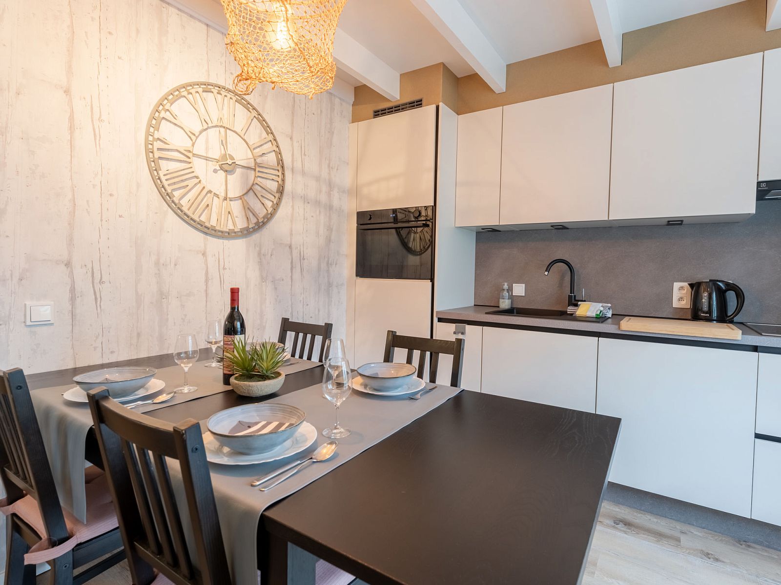 Gezellige eetruimte in Vakantiehuis Strandhuis, Bredene aan de Belgische kust, met moderne keuken en sfeervol gedekte tafel.