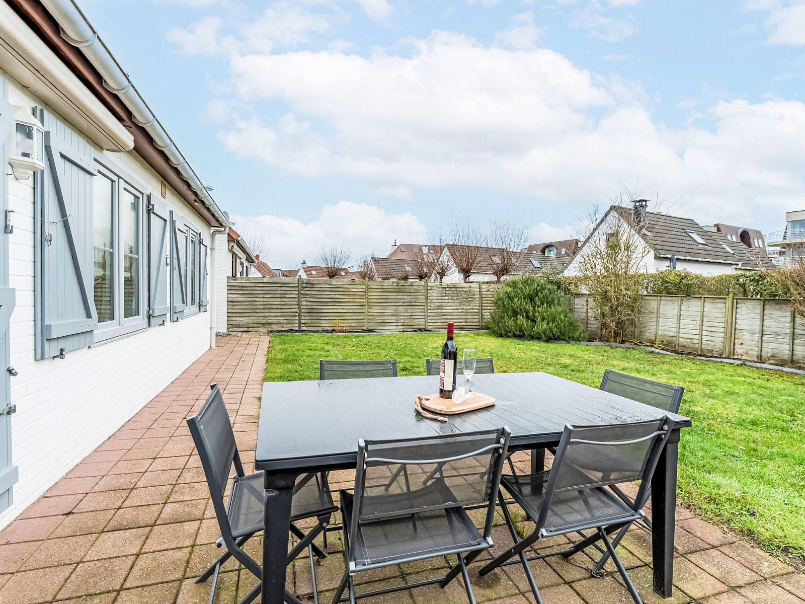 Geniet van het terras van Vakantiehuis Strandhuis in Bredene, Belgische kust, met een ruime tuin en gezellige zitplek voor een ontspannen verblijf.