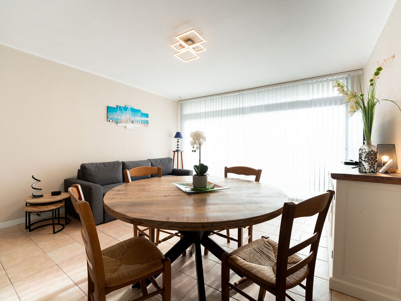 Cozy living room of Apartment Astrid 62/101 in Bredene, Belgian coast. Spacious indoor space with dining table and comfortable seating area.