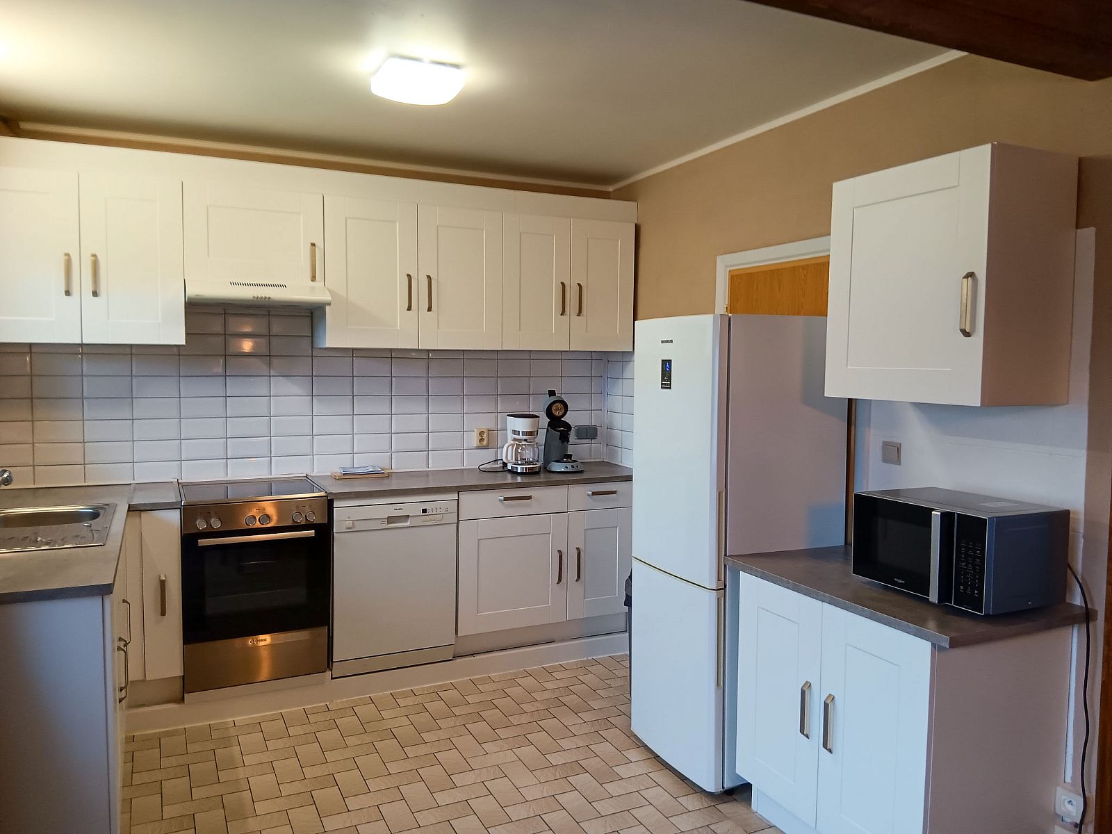 Moderne keuken in Vakantiehuis Ruiterlaan, Bredene, Belgische kust. Gezellige ruimte met witte kasten en moderne apparatuur.