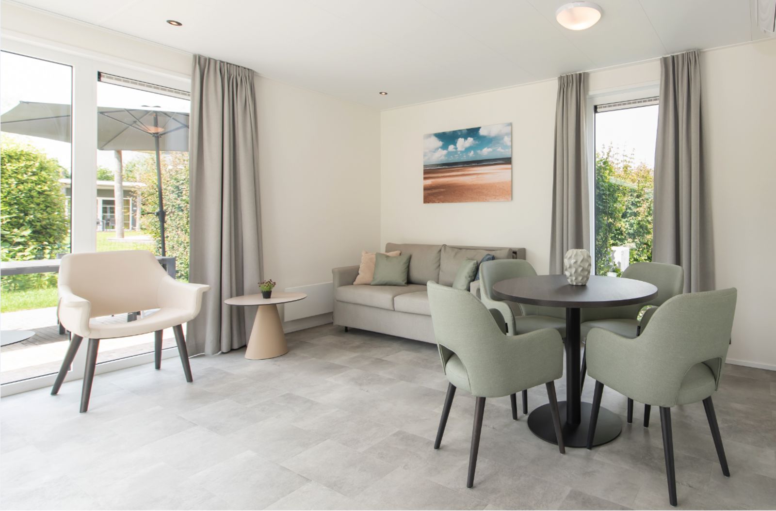 Moderne woonkamer in Access Lodge, vakantiehuis in Westende, Belgische kust, met stijlvolle inrichting en uitzicht op de groene omgeving.