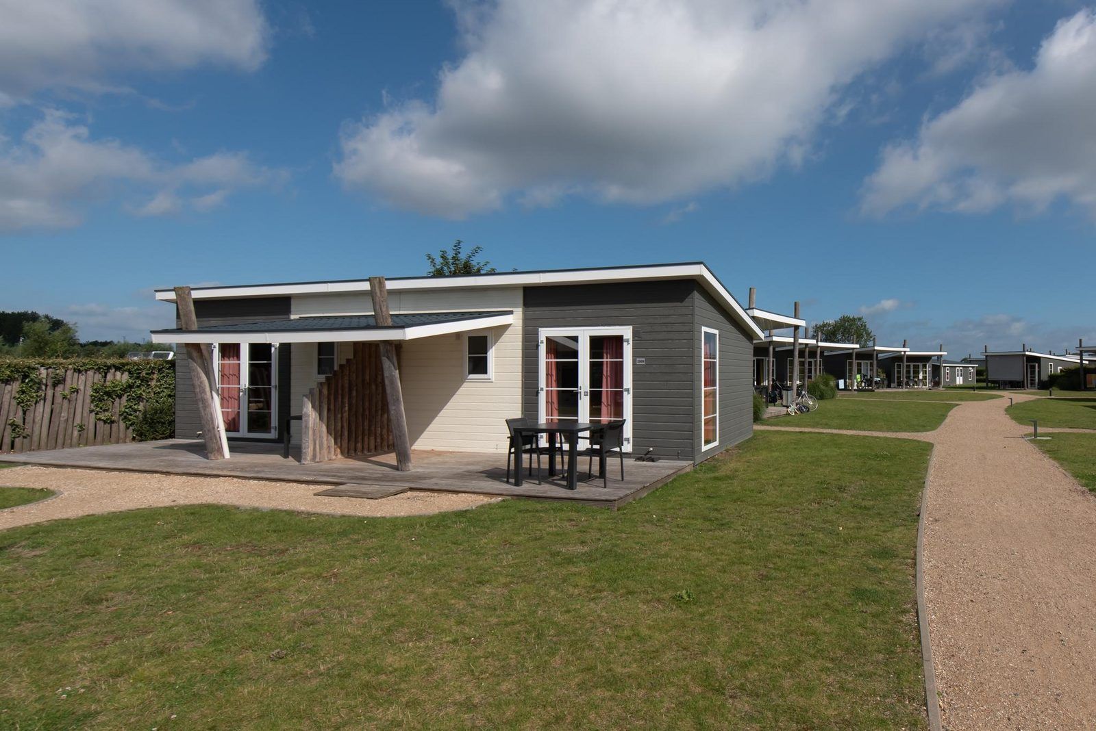 Comfort Lodge in Westende, Belgische kust, vakantiehuis met veranda, omgeven door groen en blauwe lucht, honden toegestaan, met airco.