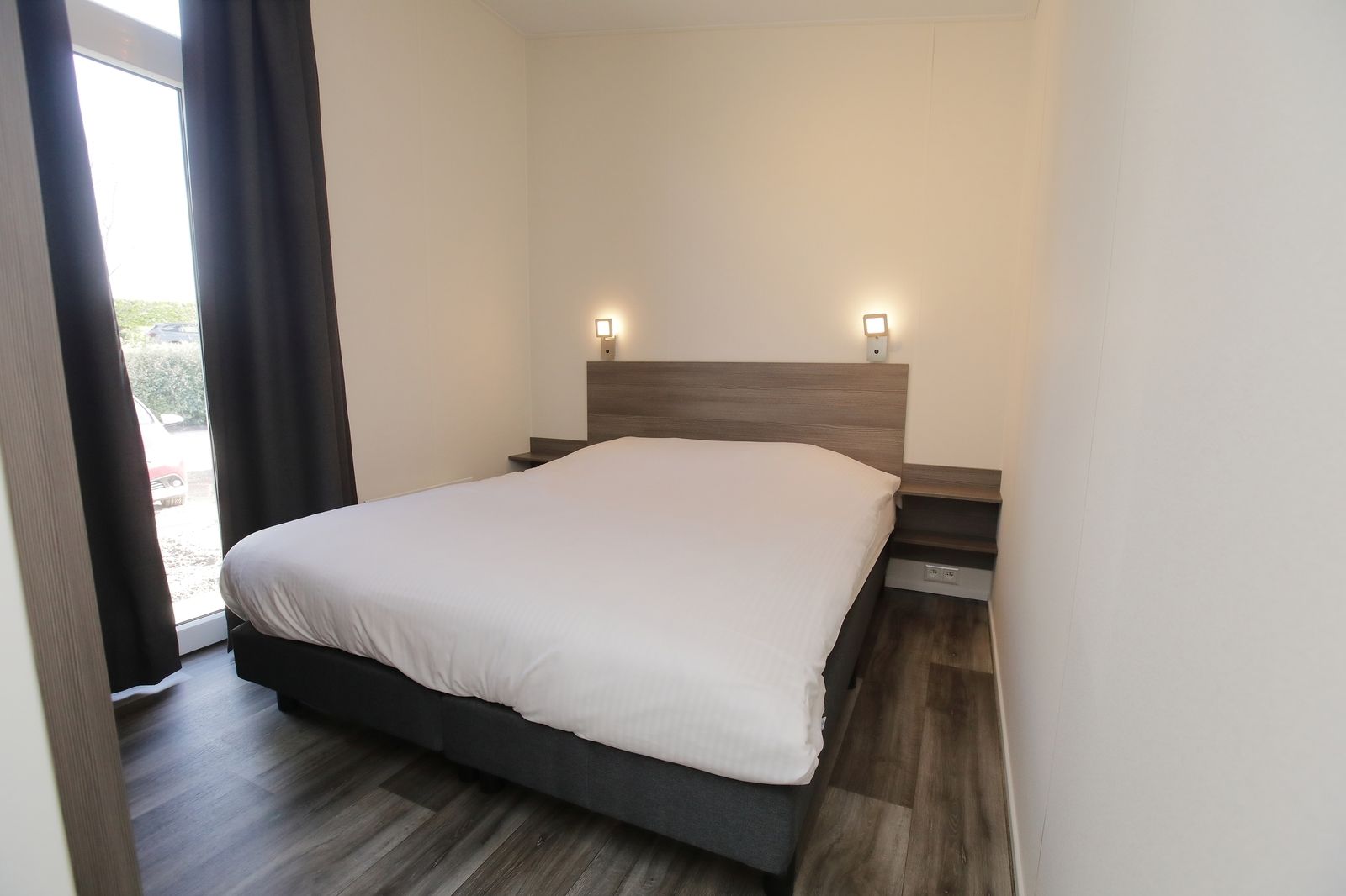 Slaapkamer van Premium Lodge I 6 personen in Nieuwpoort, Belgische kust. Comfortabel vakantiehuis met moderne inrichting en natuurlijke lichtinval.