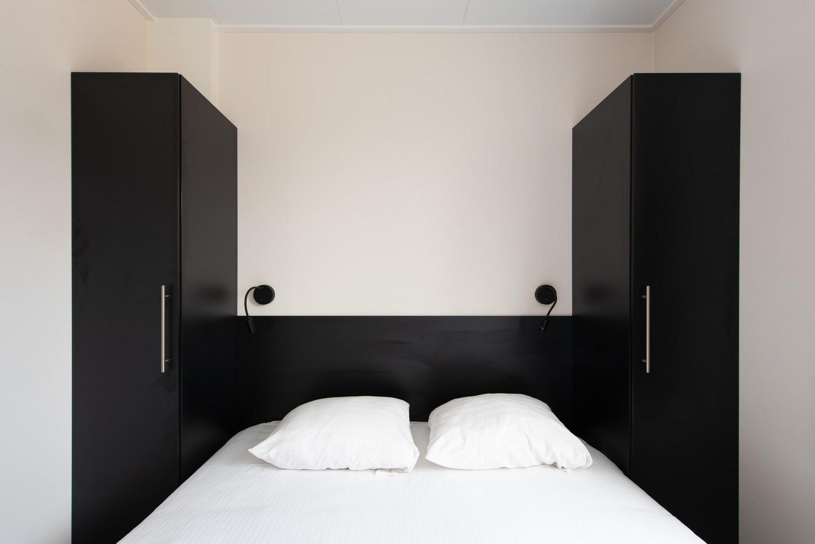 Slaapkamer in Wood Lodge, een luxe vakantiehuis in Nieuwpoort aan de Belgische kust, met comfortabele bedden en moderne inrichting.