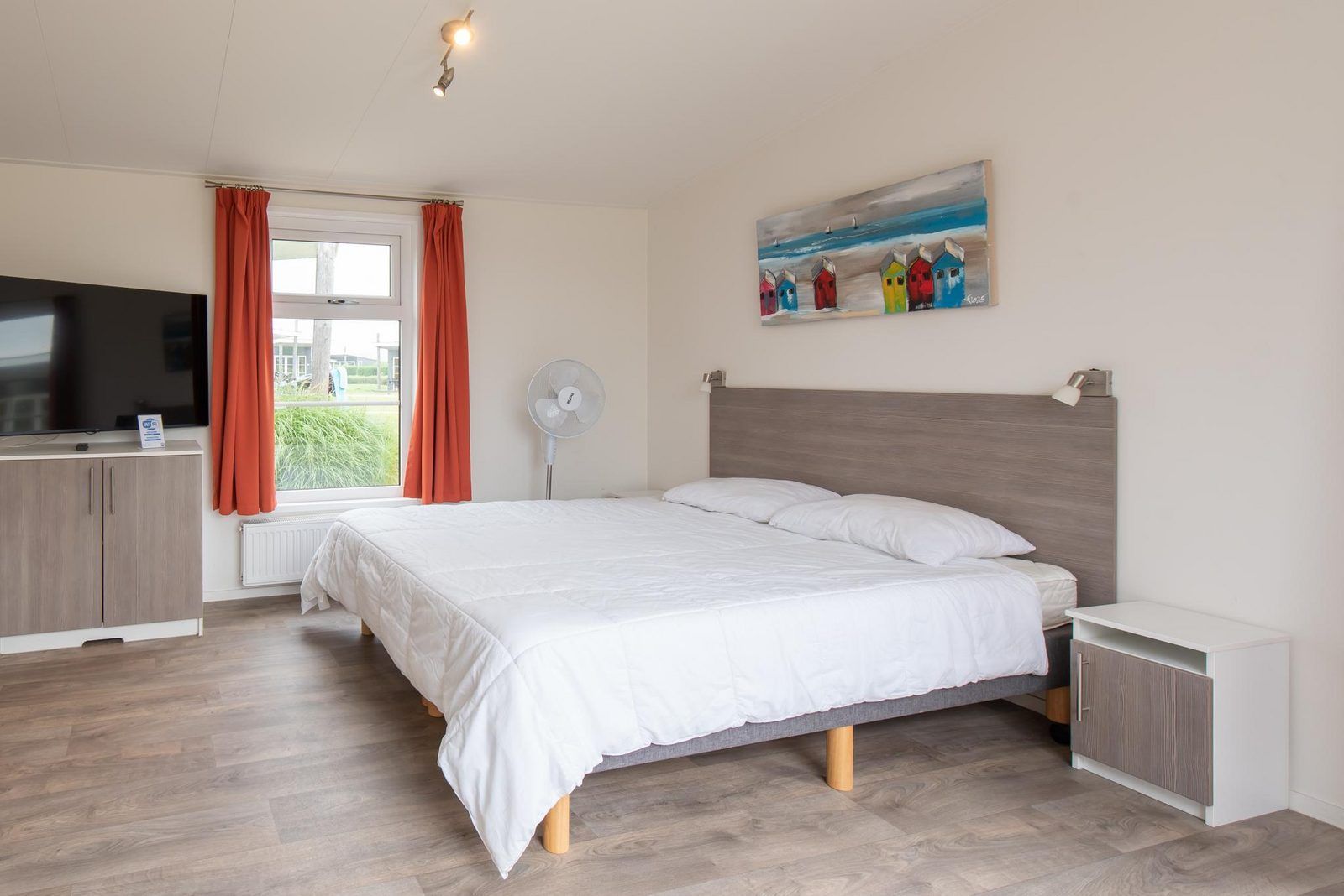 Comfort Lodge in Nieuwpoort, Belgische kust: knusse slaapkamer met modern interieur en kunstwerk, ideaal vakantiehuis voor twee personen.
