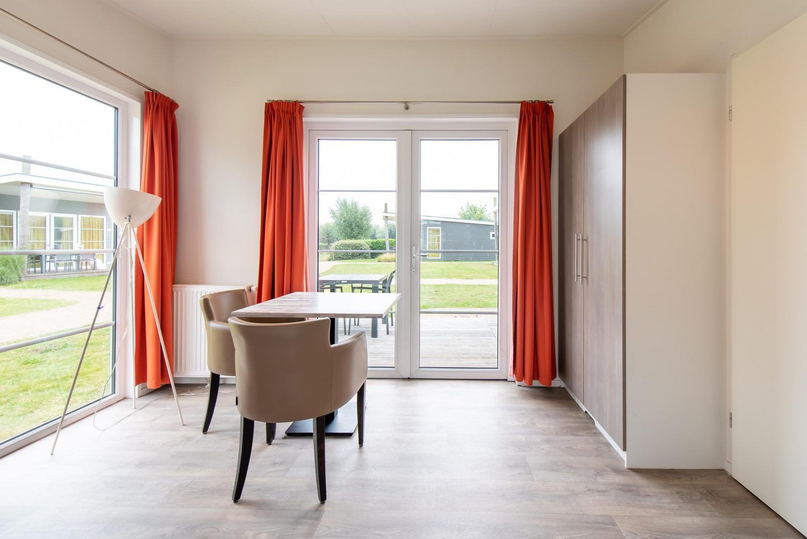Binnenruimte van Comfort Lodge in Nieuwpoort, Belgische kust, met uitzicht op terras en groene omgeving, ideaal voor een ontspannen vakantie.
