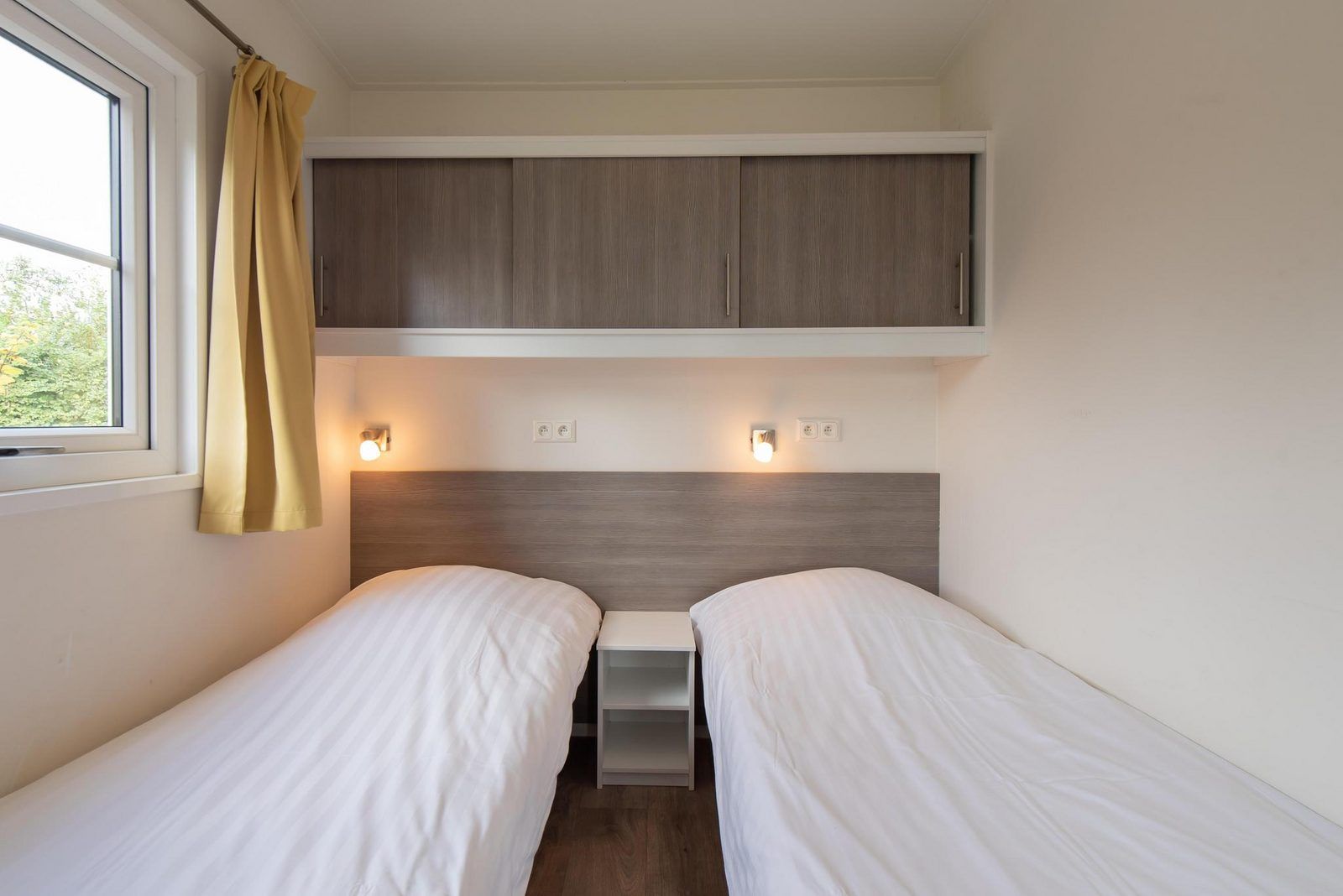 Slaapkamer in Comfort Lodge, Nieuwpoort: knusse ruimte met twee bedden en moderne inrichting, ideaal voor een ontspannen verblijf aan de Belgische kust.