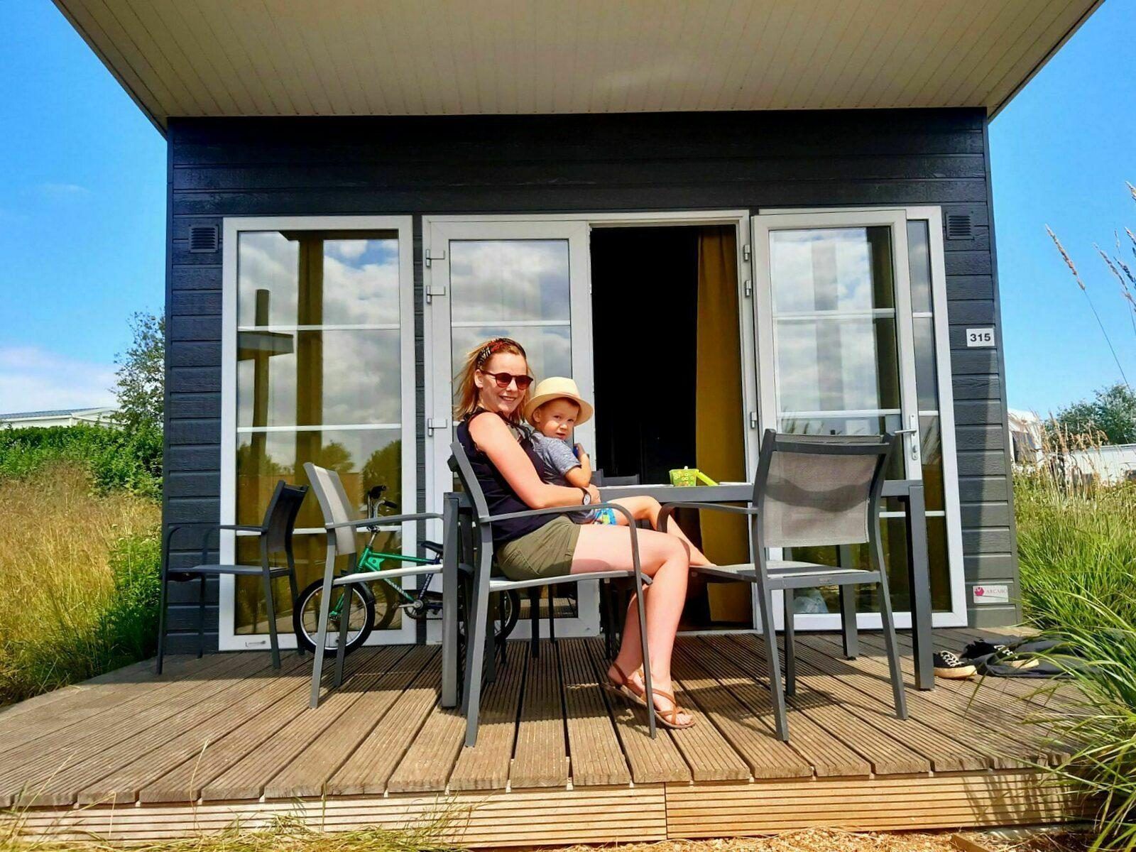 Geniet van de zon op de veranda van Comfort Lodge, een vakantiehuis in Nieuwpoort aan de Belgische kust, ideaal voor een ontspannen verblijf.