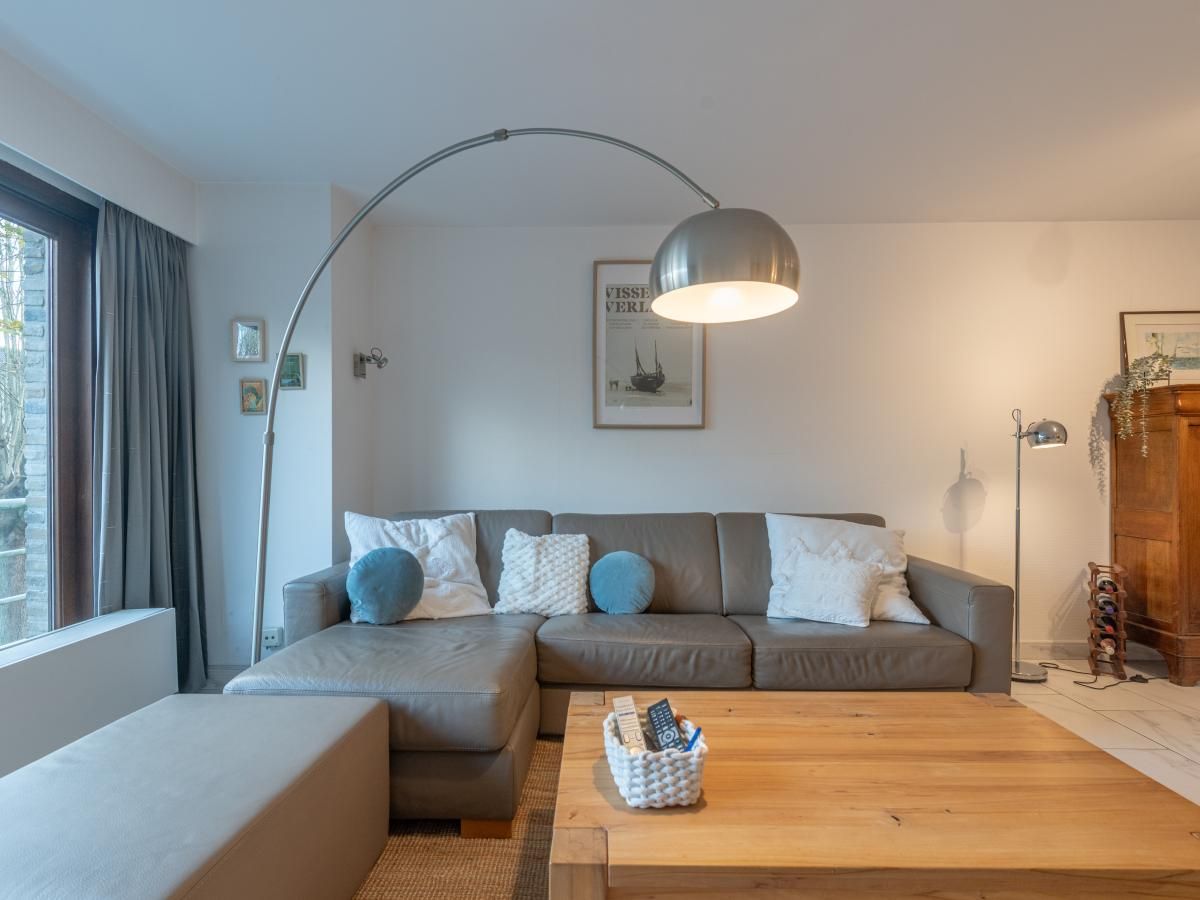 Gezellige woonkamer in Reigersnest vakantiehuis, Nieuwpoort aan de Belgische kust, met stijlvol interieur en veel natuurlijk licht.