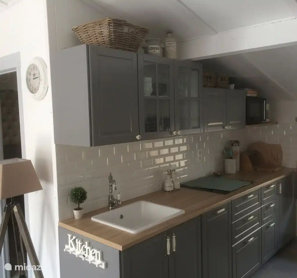 Moderne Kueche in "Het Toeval", einem Ferienhaus in Oostduinkerke an der belgischen Kueste, mit stilvollen grauen Schraenken und einer Arbeitsplatte aus Holz.