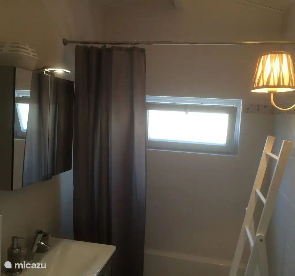 Modernes Badezimmer im Ferienhaus "Het Toeval" in Oostduinkerke an der belgischen Kueste mit stimmungsvoller Beleuchtung und praktischen Ausstattungsmerkmalen.
