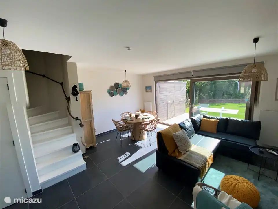 Gemuetliches Wohnzimmer des Ferienhauses "Witte Oase" in Oostduinkerke an der belgischen Kueste, mit moderner Einrichtung und Blick auf den Garten.