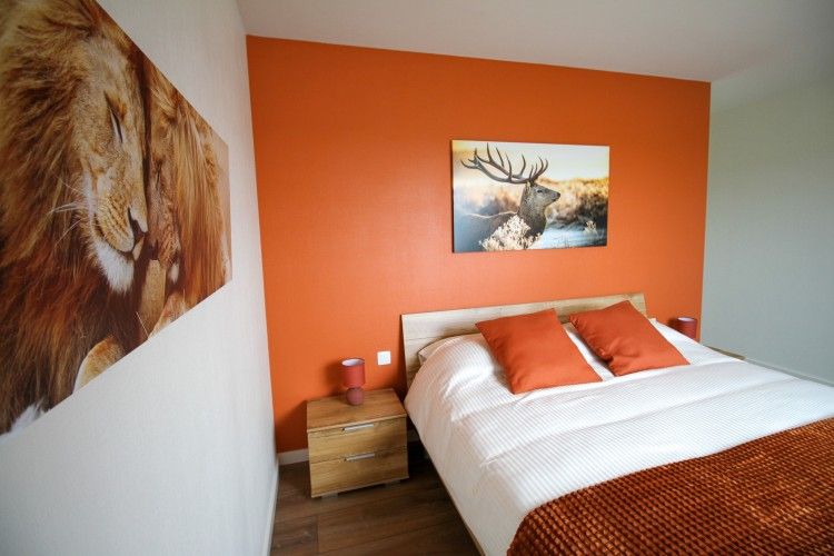 Gemuetliches Schlafzimmer in Duinvilla amuZee, Oostduinkerke, mit warmen Farben und moderner Kunst an der belgischen Kueste.