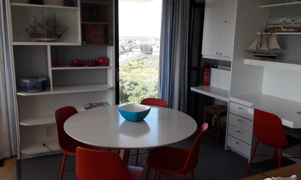 Gezellige eetruimte in appartement Nieuwpoort-Bad, Belgische kust, met uitzicht op de omgeving, ideaal voor een ontspannen vakantie.
