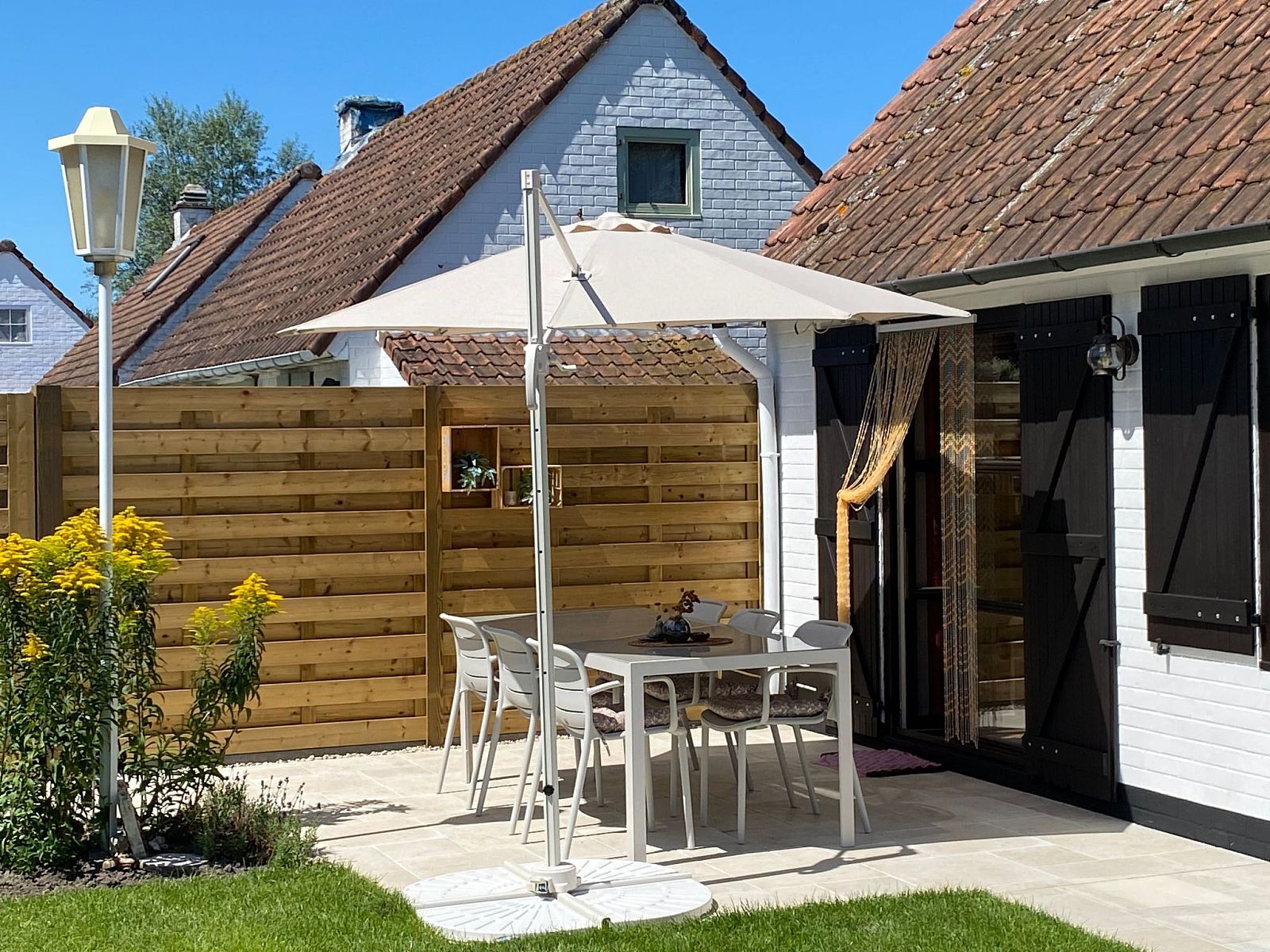 Geniessen Sie die sonnige Terrasse des Ferienhauses Zonnewind, das in der Naehe der Duenen und des Waldes in De Panne an der belgischen Kueste liegt und perfekt zum Entspannen ist.
