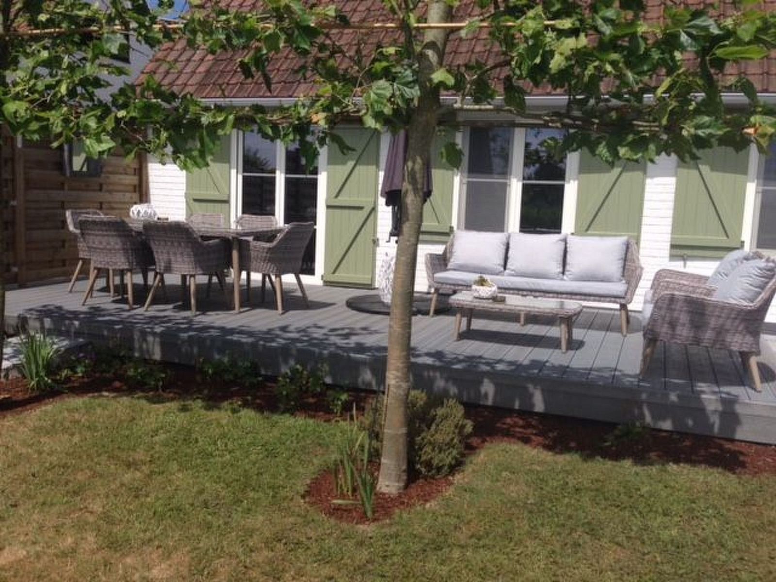 Entspannen Sie sich auf der Terrasse des Ferienhauses Windekind mit Blick auf die Felder in De Panne an der belgischen Kueste, mit bequemen Sitzgelegenheiten und Blick auf den Garten.