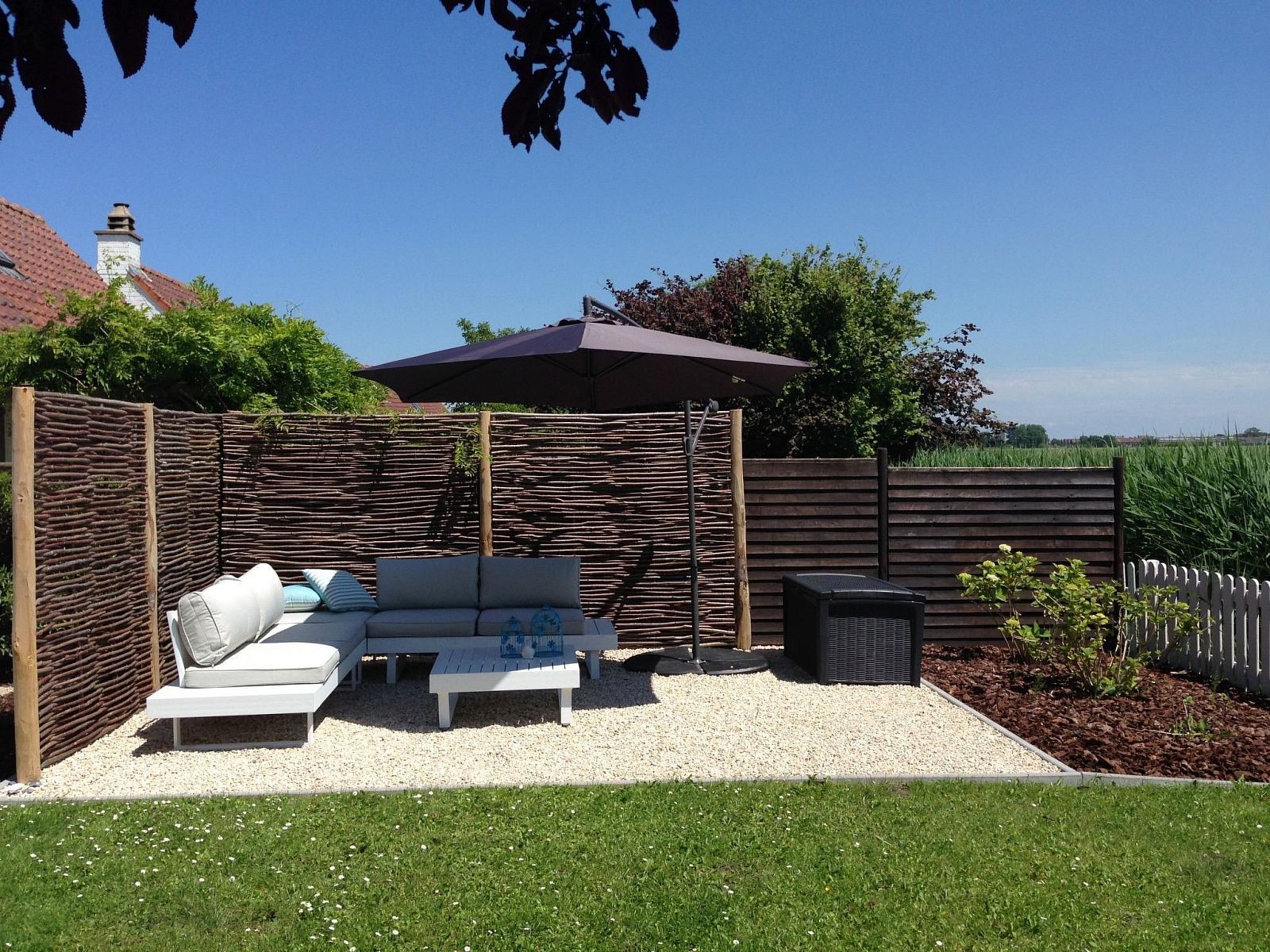 Geniessen Sie die Sonne auf der Terrasse des Ferienhauses Polderwind mit Blick auf die Felder in De Panne, Belgische Kueste, Belgien.