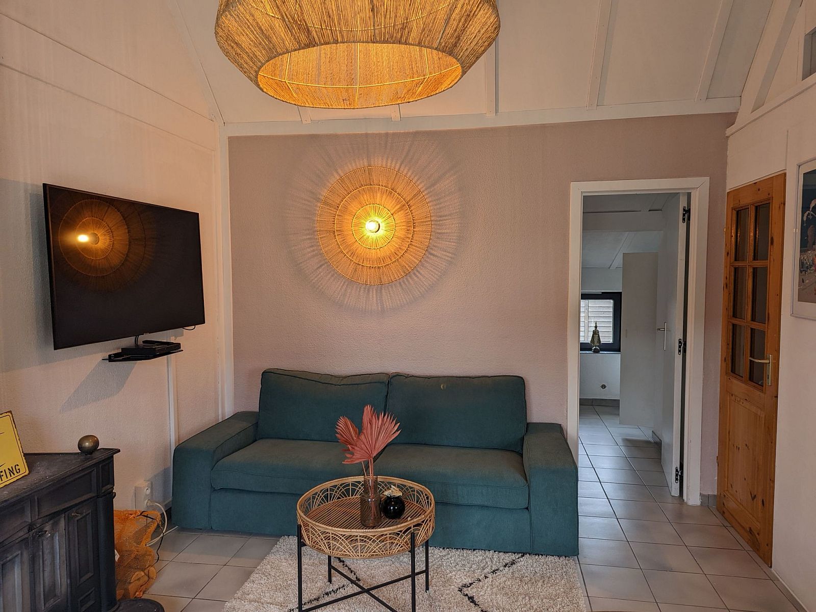 Gemuetliches Wohnzimmer im Ferienhaus Duinendaele II, De Panne, belgische Kueste mit bequemem Sofa und stimmungsvoller Beleuchtung.