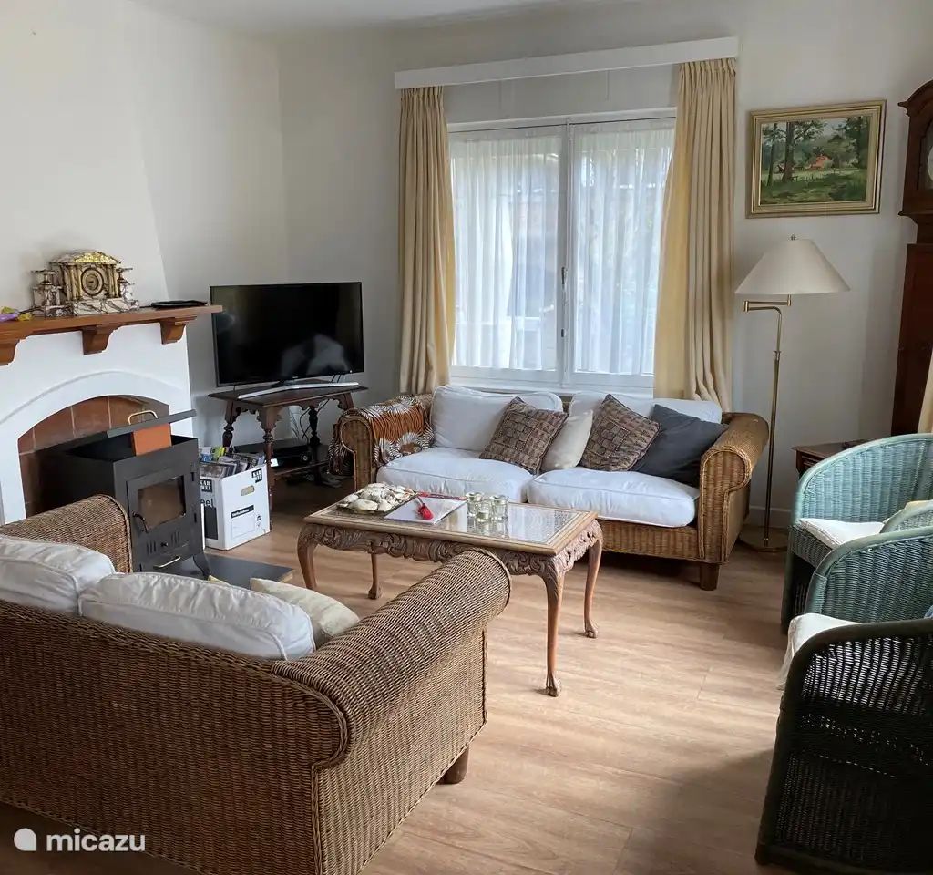 Gemuetliches Wohnzimmer im Ferienhaus "Quiet Corner" in De Panne an der belgischen Kueste, mit einer bequemen Sitzecke und rustikaler Einrichtung.