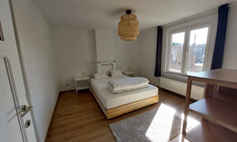 Gemuetliches Schlafzimmer im Ferienhaus "De Zji" in De Panne an der belgischen Kueste, mit grossem Fenster und moderner Einrichtung fuer einen entspannten Aufenthalt.