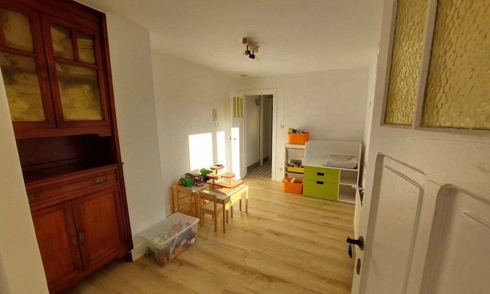Gemuetlicher Innenbereich des Ferienhauses "De Zji" in De Panne an der belgischen Kueste, mit Holzmoebeln und einer Spielecke fuer Kinder.