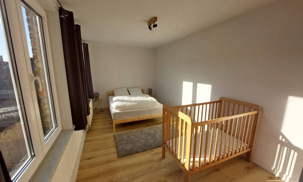 Gemuetliches Schlafzimmer im Ferienhaus "De Zji" in De Panne an der belgischen Kueste, mit einem bequemen Bett und einem Kinderbett fuer Familien.