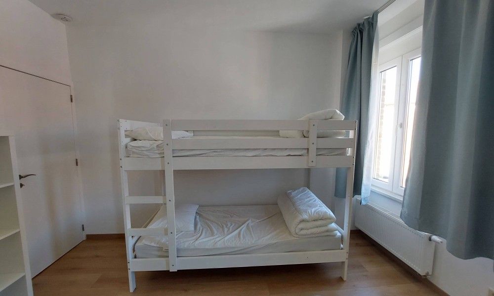 Gemuetliches Schlafzimmer im Ferienhaus "De Zji" in De Panne an der belgischen Kueste, mit Etagenbett und Tageslicht durch grosse Fenster.