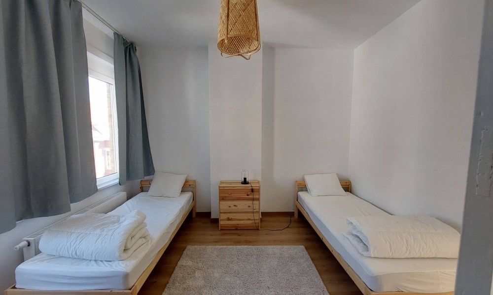 Gemuetliches Schlafzimmer im Ferienhaus "De Zji" in De Panne an der belgischen Kueste, mit zwei Einzelbetten und rustikaler Einrichtung.